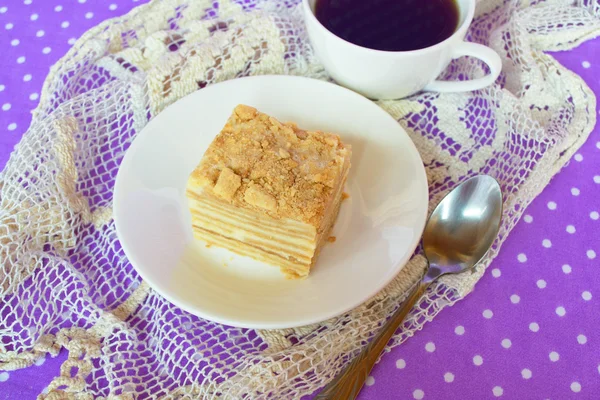 酥和甜甜的奶油蛋糕。一块蛋糕在板，咖啡杯，勺子。美味的甜点 — 图库照片