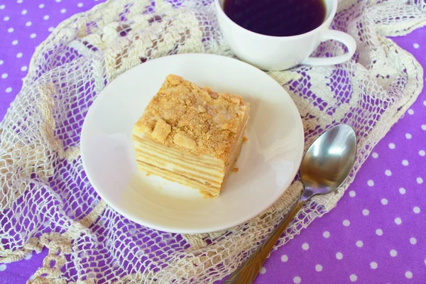 Cake of puff pastry and sweet custard. Piece of cake on the plate, coffee Cup, spoon. A delicious dessert — Stock Photo, Image