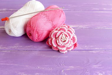 Ev yapımı pembe ve beyaz tığ işi çiçek boncuk ile dekore edilmiştir. İki skeins pamuk iplik ve Lila ahşap zemin üzerine kanca kroşe