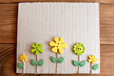 Kart karton kutu, plastik düğmeler, yaprakları ve mumlu kablosu yapılır. Ahşap arka plan metin için boş alan ile 