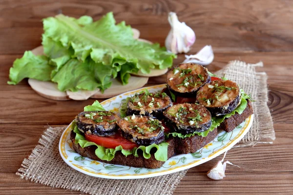 Roti hitam panggang dengan terong panggang, tomat segar, selada, bawang putih, dill. Selada hijau di papan tulis, bawang putih — Stok Foto