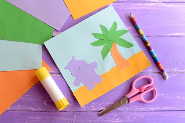 Θερινή κάρτα χαρτί, ψαλίδι, κόλλα stick, χρωματισμένα φύλλα χαρτιού σε λιλά ξύλινα φόντο. Ιπποπόταμος και παλάμη δέντρο προσχολικής ηλικίας σκάφη. Ζώα χειροτεχνίας τέχνες ιδέα προγράμματος για παιδιά — Φωτογραφία Αρχείου