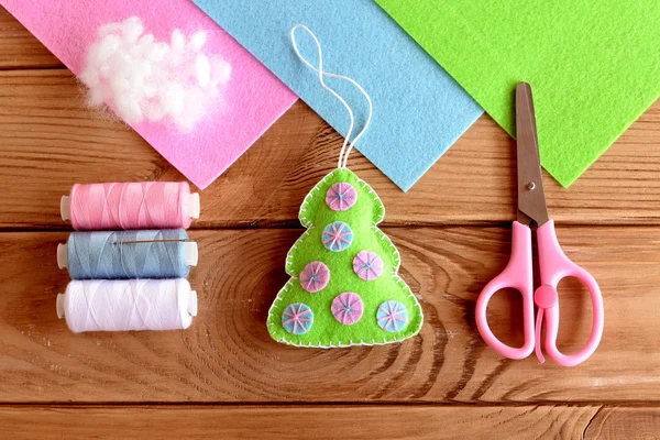 Zelfgemaakte vilten kerstboom decor. Zelfgemaakte kerstboom diy ornament. Handwerk idee voor kinderen. Draadset, hollofayber, schaar op een houten tafel. Bovenaanzicht. Tutorial. Winterminimalisme kunst. Hand naaien stap praktijk voor kinderen — Stockfoto