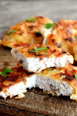 Kıyılmış Türkiye biftek kızarmış yumurta hamuru ve taze otlar ile süslenmiş. İştah açıcı kızarmış et dilimleri kesme tahtası ve eski bir ahşap arka plan. Portre