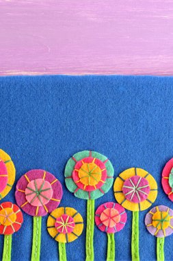 Karışık keçe çiçekli metin için boş yer ile mavi arka plan üzerinde. Alacalı çiçek aplike çocuklar için. Doğum günü, Paskalya, Sevgililer günü, anneler günü için çiçek tebrik kartı 