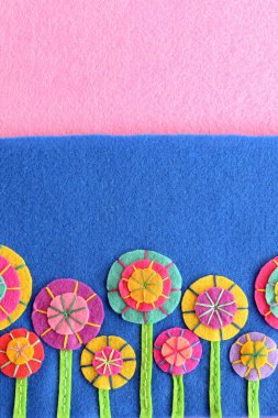 Renkli Keçe çiçek kopya alanı için metin mavi ve pembe bir arka plan olarak ayarlayın. El el sanatları şirin çiçekler. Çiçek craft bezemeler. Anneler günü, doğum günü tebrik kartı için şenlikli 