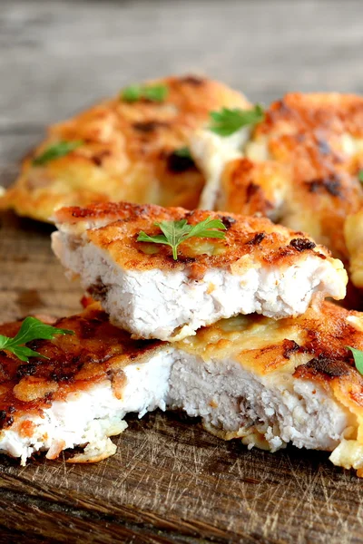 Kıyılmış Türkiye biftek kızarmış yumurta hamuru ve taze otlar ile süslenmiş. İştah açıcı kızarmış et dilimleri kesme tahtası ve eski bir ahşap arka plan. Portre