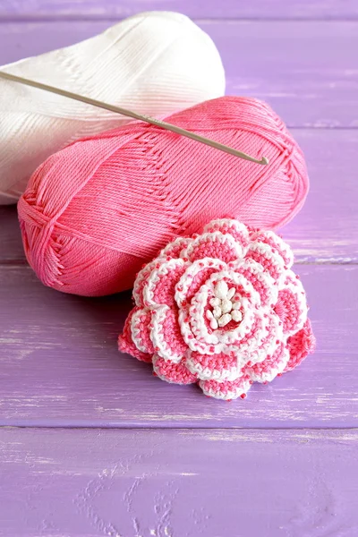 Home pink and white crochet rose two skeins of cotton yarn and crochet hook on lilac wooden background. Cute beaded flower pattern photo. Hand beautiful flower idea — Stock Photo, Image