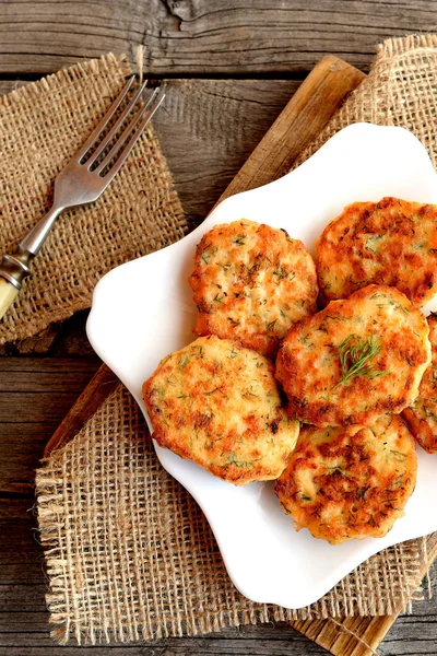 Costolette di salmone con aneto su un piatto, forchetta su un tavolo di legno. Deliziose polpette di salmone fritte in una padella. Ricetta di frutti di mare. Vista dall'alto — Foto Stock