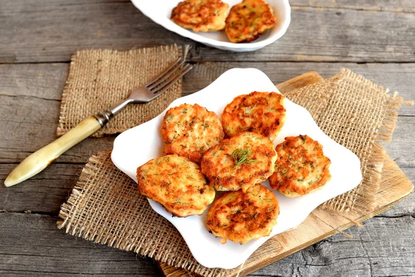 Smażone czerwone ryby kotlety na talerzu i na deski do krojenia, widelec na juta na starym drewnianym tle. Pyszne patties gotowane z posiekane filet z łososia, jajka, cebula i koperek i smażone w oliwie z oliwek — Zdjęcie stockowe