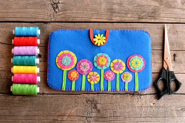 Tablet Cover. Filt blå fallet med ljusa blommor, tråd set, sax på gamla trä bakgrund. Elektronik tillbehör hantverk. Översta vyn. Närbild — Stockfoto