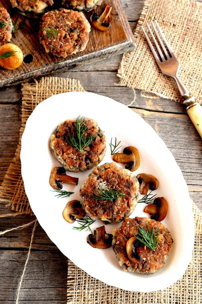 Burgers aux champignons frits avec oignon et épices dans une assiette. Galettes de escalopes de champignons végétariens maison. Délicieuse recette végétarienne et diététique. Galettes frites maison végétariennes. Vue du dessus — Photo