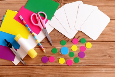 Kartları ve daire, makas, kalem, tutkal, renkli kağıt sayfalarının ahşap bir masaya kesilmiş. Nasıl eğitim flashcards çocuk eğitimi için karton üzerinden yapmak. Üstten Görünüm. Öğretici. Adım 