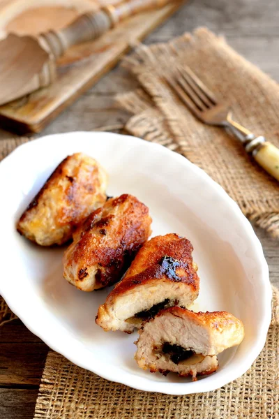 Kleine heerlijk vlees broodjes gevuld met geraspte kaas en gebakken champignons. Geroosterde Turkije rolt op een bord en op oude houten achtergrond. Turkije borst recept. Closeup — Stockfoto