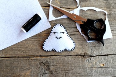 Küçük beyaz Cadılar Bayramı hayalet süsleme, makas, siyah iplik, adet ve keçe eski ahşap arka plan üzerinde artıkları. Dikiş seti. Çocuk Sanat sonbahar tatil. Öğretici. Portre 