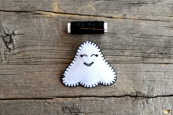 Lindo adorno fantasma de Halloween y el hilo negro aislado en el fondo de madera vieja. Juguete de mano está hecho de fieltro blanco. Lección de costura fácil para niños. ¡Paso! Primer plano. —  Fotos de Stock