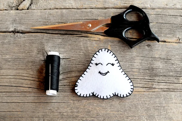 Muñeca fantasma de Halloween blanco, tijeras, hilo negro, aguja sobre fondo de madera viejo. Decoración de fieltro festiva hecha en casa. Idea artesanal para niños de todas las edades. Un tutorial paso a paso de costura. Primer plano. —  Fotos de Stock