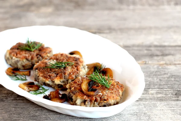 Delicious fried mushroom cutlets on a plate and wooden table. Healthy vegetarian cutlets. Mushroom dish. Homemade food photo