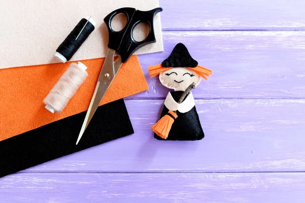 Funny Halloween witch made of felt, scissors, thread set, orange, beige and black felt sheets on wooden background with blank space for text. Halloween sewing crafts for kids. Inspiration DIY — Stock Image Funny Halloween witch made of felt, scissors, thread set, orange, beige and black felt sheets on wooden background with blank space for text. Halloween sewing crafts for kids. Inspiration DIY Royalty Free Stock Photos