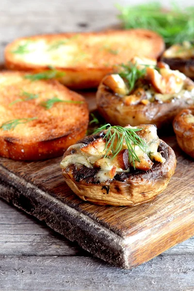 Daging dan keju julienne dipanggang dengan topi jamur, dipanggang di papan kayu. Penutup — Stok Foto