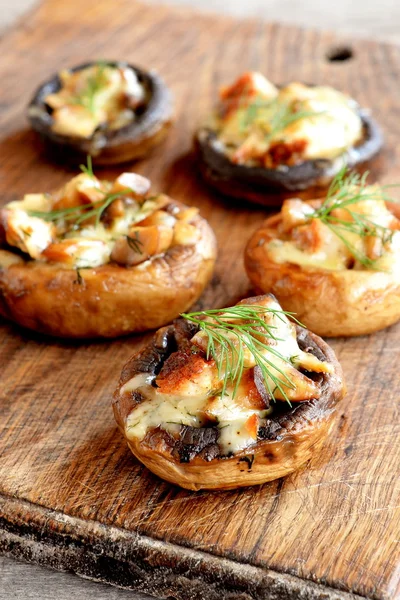 Gorras de champiñones rellenos al horno con queso, carne y especias. Setas rellenas sobre un fondo de madera. Deliciosa receta simple aperitivo — Foto de Stock