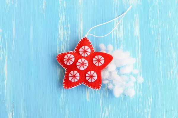 Encha o ornamento de estrela de Natal sentido com a fibra oca. Natal costura artesanato diy artesanato. Enfeite estrela pendurado vermelho decorado com bolas brancas em um fundo azul. Como ensinar uma criança a costurar o passo do tutorial. Árvore de decoração de ano novo. Vista superior — Fotografia de Stock