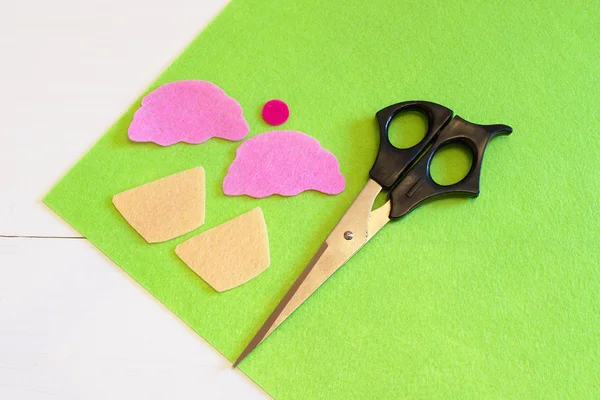 Вырезать детали войлока для кексовых игрушек, ножниц. Легкий детский проект DIY. Шитье для начинающих. Шаг — стоковое фото