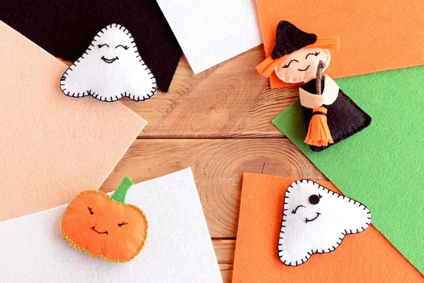 Şirin Halloween DIY hissettim. Ev yapımı küçük cadı süpürge, kabak kafa ile iki hayaletler. Cadılar Bayramı oyuncak, keçe parçaları ile metin için boş yer ahşap arka plan üzerinde renkli. Sonbahar çocuklar el sanatları fikir dikiş — Stok fotoğraf