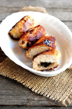 Küçük doldurulmuş hindi eti bir tabak ve eski ahşap masa üzerinde rulo. Kızarmış hindi göğüs peynir ve agaricus ile rulo. Et yemeği dolması. Rustik tarz. Dikey fotoğraf 