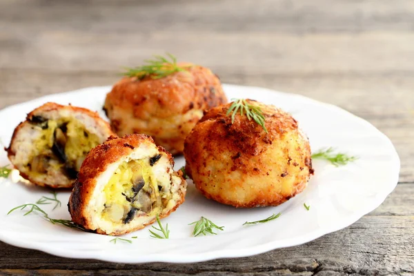 Patatas de carne frita rellenas de queso y champiñones fritos en plato sobre fondo de madera. Patatas rellenas caseras preparadas a partir de carne picada. Primer plano. — Foto de Stock