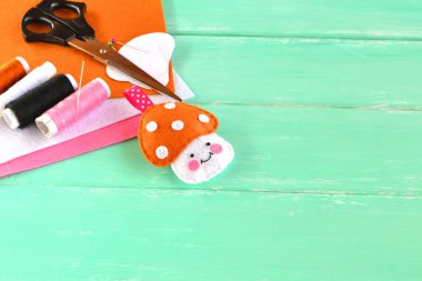 Keçe oyuncak mantar, Tel, iğne, makas, yeşil ahşap arka plan, metin için boş yer 