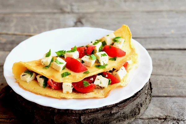 Telur dadar goreng diisi dengan keju, tomat dan peterseli. Isian omelet di piring dan pada latar belakang kayu tua. Resep telur dadar. Penutup — Stok Foto