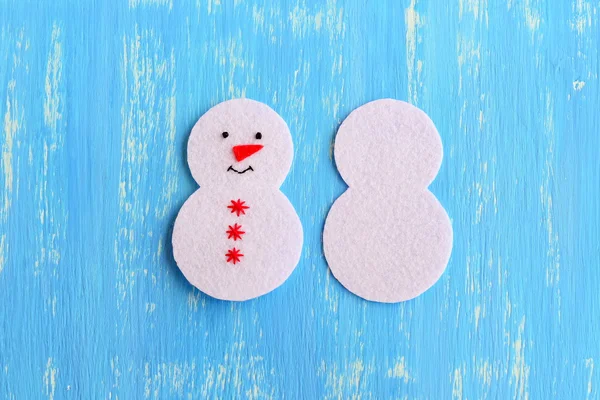 Cómo coser un adorno de muñeco de nieve de Navidad. Decoración de Navidad DIY hecho a mano paso a paso. Corte de fieltro blanco detalles para coser adorno del árbol de Navidad. Por un lado bordado con hilo negro ojos y boca, hilo rojo copos de nieve y nariz —  Fotos de Stock