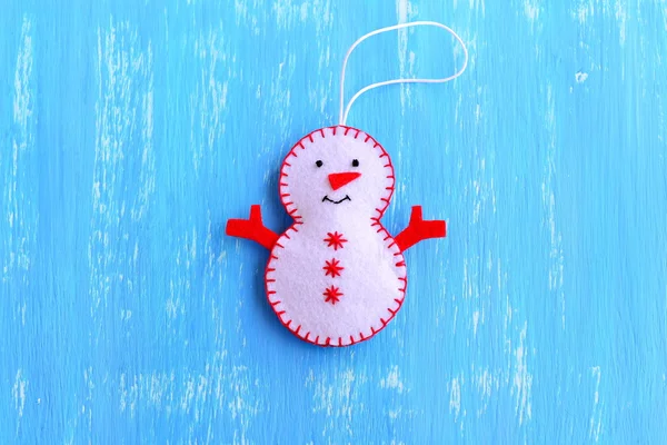 Fun felt Christmas tree snowman ornament isolated on a blue wooden background. How to sew a Christmas snowman ornament. Christmas kids workshop step by step. Christmas tree decor idea for chilfren. Easy felt sewing crafts. Top view — Stock Photo, Image