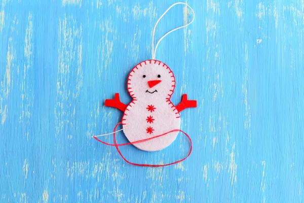 Cómo coser un adorno de muñeco de nieve de Navidad. Bricolaje paso a paso. Únete a los bordes de fieltro del ornamento de muñeco de nieve de Navidad con hilo rojo utilizando una puntada de manta decorativa. Instrucción de artesanía de árboles de Navidad para niños. Decoración de año nuevo — Foto de Stock