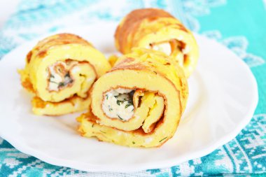Peynirli omlet ve rulo bir plaka üzerinde. Doldurulmuş omlet