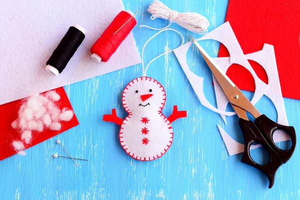 Eğlenceli yılbaşı kardan adam süsleme, makas, Tel, iğne, iğne, kordon, adet ve hurda ahşap arka plan üzerinde hissettim hissettim. Nasıl bir Noel kardan adam süsleme yapmak. Adım. El yapımı keçe el sanatları. Üstten Görünüm 