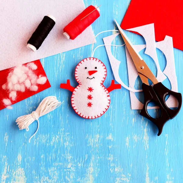 Симпатичный рождественский снеговик украшения, ножницы, нить, игла, шнур, войлочные простыни и объедки на деревянном фоне. Швейные принадлежности для изготовления снеговика ручной работы. Рождественские детские поделки. Рождественские дети. Вид сверху — стоковое фото