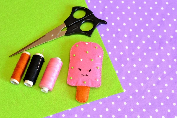 Lindo juguete helado de fieltro. Patrón de comida fieltro. Comida bricolaje. Fácil artesanía para niños. Hilos, sábanas de lana marrón y rosa. Fondo divertido de verano — Foto de Stock