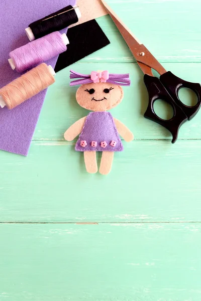 Handmade doll, scissors, thread set, needle, felt sheets on wooden background with copy space for text. How simply and cheaply make a kids toy. Cute doll crafts with felt for kids — Stock Photo, Image