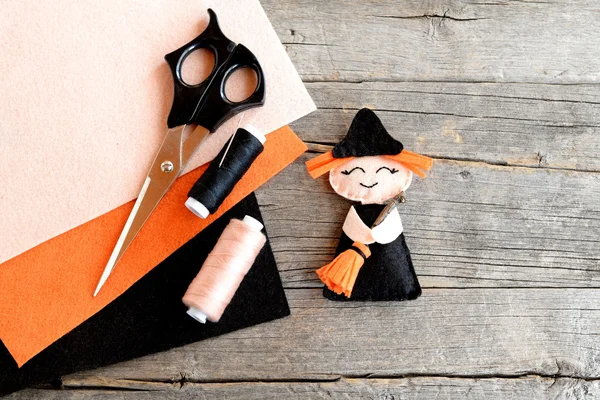 How to sew a Halloween witch decor. Step. Halloween felt witch with broom, beige and black thread, needle, scissors, felt set on old wooden background. Easy Halloween doll crafts for kids. Top view. DIY hand sewing activities for kids children — Stock Photo, Image