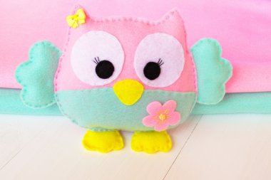 Beyaz ahşap arka plan, pembe ve mavi hissettim rulo üzerinde baykuş keçe 