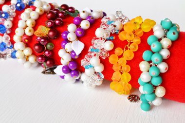 Bir dizi bilezik. Plastik boncuk ve yaprakları ile güzel renkli bilezikler