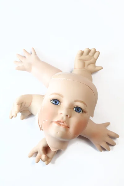 Gebrochener Puppenkopf und Körperteile auf weißem Hintergrund — Stockfoto