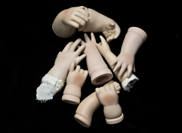Doll Body Parts on Black Background