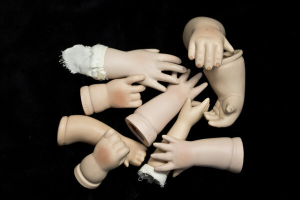 Doll Body Parts on Black Background