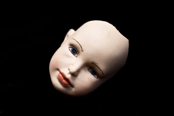 Gros plan des têtes et des pièces de poupée cassées sur fond noir — Photo