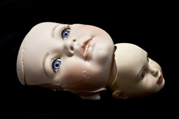 Nahaufnahme von kaputten Puppenköpfen und Teilen auf schwarzem Hintergrund — Stockfoto