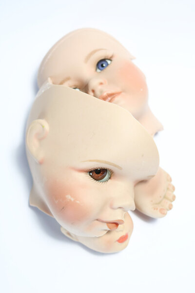 Broken Doll Body Parts on White Background
