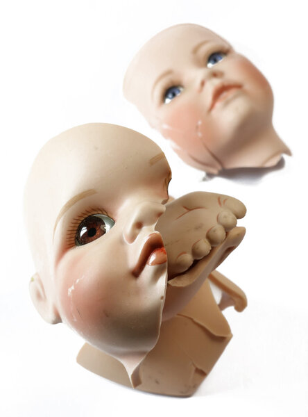 Broken Doll Body Parts on White Background